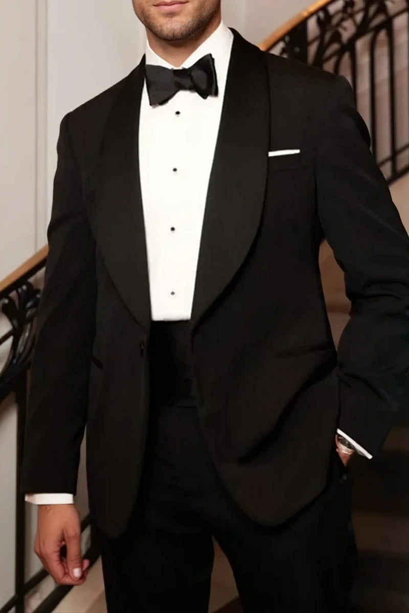 Man wearing a classic black formal blazer over a white shirt, paired with grey trousers.